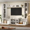 A white TV wall unit with a TV mounted on it, shelves, and cabinets, set up in a living room. Anteprima dell’immagine prodotto