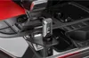 A car's center console with an FM transmitter plugged into the cigarette lighter socket. Anteprima dell’immagine prodotto
