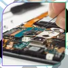 A close-up of a person's hands using tweezers to work on a circuit board, likely a smartphone. Produktbild-Vorschau
