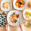 A table setting with multiple plates of food, cutlery, and a drink, suggesting a meal. Náhled obrázku produktu