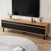 A modern TV stand with a black ribbed front and a natural wood top, placed in a living room setting with a large TV mounted on the wall. Produktbild-Vorschau