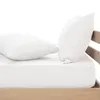Two white pillows on a white bed sheet, with a wooden bed frame visible on the right. Produktbild-Vorschau