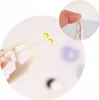 A close-up of a hand holding white tweezers, with two yellow curved lines indicating the tips of the tweezers. The background is blurred. Produktbild-Vorschau