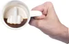 A hand holds a white mug filled with coffee. The mug has a raised middle finger design inside. Produktbild-Vorschau