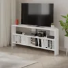 A white corner TV stand with a TV, game console, controllers, speakers, and books. Produktbild-Vorschau