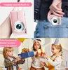 A collage showing a pink digital camera being held and placed in a pocket, and children receiving gifts. Produktbild-Vorschau