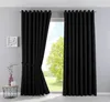 A room interior with black curtains drawn across a window, with a small side table and decorative items on the left. Produktbild-Vorschau