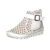 A white boot with a tan decorative pattern and a buckle. Produktbild-Vorschau