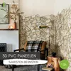 A living room corner decorated with stone-look wall panels, a chair with a blanket, and a lamp. Produktbild-Vorschau