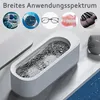 Collage showing various small items being cleaned in an ultrasonic cleaner, with text overlay. Produktbild-Vorschau