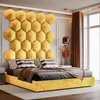 A luxurious bedroom featuring a large, hexagonal yellow upholstered headboard and a matching yellow bed frame. Produktbild-Vorschau