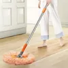 A person is using a mop to clean a wooden floor in a room with white cabinets. Náhled obrázku produktu