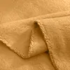 A close-up view of a folded yellow polar fleece blanket, showing the texture and stitching along the edge. Produktbild-Vorschau