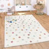 A child's playroom with a polka dot rug, toys, and furniture. Produktbild-Vorschau