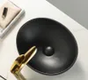 A black ceramic sink with a gold faucet on a white countertop. Náhľad obrázku produktu
