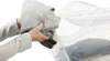 A person is placing a grey sweater into a clear plastic storage box. Produktbild-Vorschau