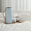 A breakfast tray with a coffee thermos, a cup of coffee, an egg in an egg cup, and a slice of toast on a bed. Produktbild-Vorschau