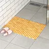A bathroom scene with a bamboo bath mat and slippers. Voir les images du produit