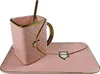 A pink ceramic cup and saucer set with a gold spoon, designed to resemble a handbag. Produktbild-Vorschau