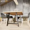 A dining table with modern chairs in a rustic-themed room with a fireplace. Podgląd zdjęcia produktu