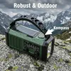 A green emergency radio with a solar panel and flashlight is placed on a rocky surface with a mountainous, cloudy background. Produktbild-Vorschau