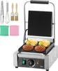 A commercial panini grill with accessories and food items on the grill. Podgląd zdjęcia produktu