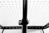 A close-up view of a black metal pole with a clamp attached, part of a net or rebounder. Podgląd zdjęcia produktu