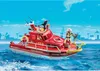 A red fire rescue boat with a firefighter figurine on it, sailing on blue water with a city skyline in the background. Produktbild-Vorschau