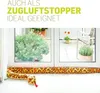 A plush snake-shaped draft stopper is placed on the floor in front of a window, with plants visible outside. Produktbild-Vorschau