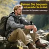 A man sitting on rocks in a natural outdoor setting, holding a portable espresso maker. Produktbild-Vorschau