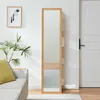 A full-length mirror with wooden frame and shelves in a living room next to a couch and a door. Náhľad obrázku produktu