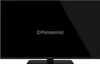 A black Panasonic TV on a stand, with the Panasonic logo displayed on the screen. Náhľad obrázku produktu