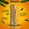 A piece of acacia firewood is shown against an orange and yellow gradient background, with green leaf-like shapes scattered around. Text describes the properties of the wood. Produktbild-Vorschau