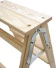 A close-up view of the top section of a wooden step stool, focusing on the hinge mechanism and the wooden planks. Produktbild-Vorschau