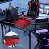 A gaming desk setup with a computer, keyboard, and chair in a room with ambient lighting. Produktbild-Vorschau