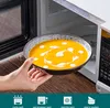 A hand is holding a bowl of soup in front of an open microwave. Náhled obrázku produktu