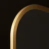A close-up view of the curved edge of a mirror with a gold frame against a black background. Náhled obrázku produktu