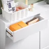 A close-up view of a white drawer pulled out from a cabinet, revealing an orange box and a brush inside. Náhľad obrázku produktu