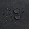 Close-up of water droplets on a dark gray textured surface. Voir les images du produit