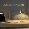 A desk with a laptop, mouse, and a gold table lamp, with a blurred bedroom background. Anteprima dell’immagine prodotto