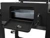 A close-up view of the open compartment of a charcoal grill, showing a metal tray inside and a pull-down shelf. Produktbild-Vorschau