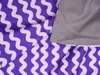 A close-up view of purple and white wavy patterned fabric, with a section of plain gray fabric visible. Produktbild-Vorschau