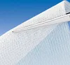 A close-up shot of white mesh material being cut by scissors against a blue background. Voir les images du produit