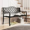 A black metal garden bench with decorative backrest, placed indoors near a staircase. There are pillows on the bench and shoes lined up in front of it. Podgląd zdjęcia produktu