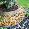 A garden bed border made of metal, filled with different colored gravels, surrounding a potted plant. Produktbild-Vorschau