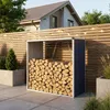 A metal firewood storage shed filled with logs, situated on a paved patio next to a wooden fence and a modern house. Podgląd zdjęcia produktu