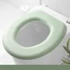 A close-up view of a green toilet seat cushion placed on a white toilet. Podgląd zdjęcia produktu