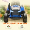 A blue toy tractor with smoke coming from the exhaust, set in an outdoor environment with grass and pumpkins. Produktbild-Vorschau