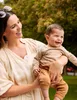 A mother holds her baby outdoors. Voir les images du produit