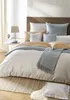 A neatly made bed with multiple pillows and a throw blanket, suggesting a bedroom setting. Produktbild-Vorschau